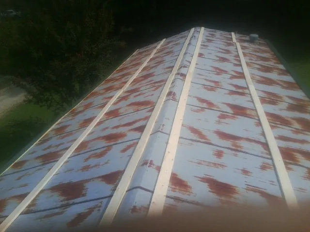 Rusted metal roof panels with new wood purlins before replacement — Storm Damage Roof Repair in Kerby by Roofing Brothers