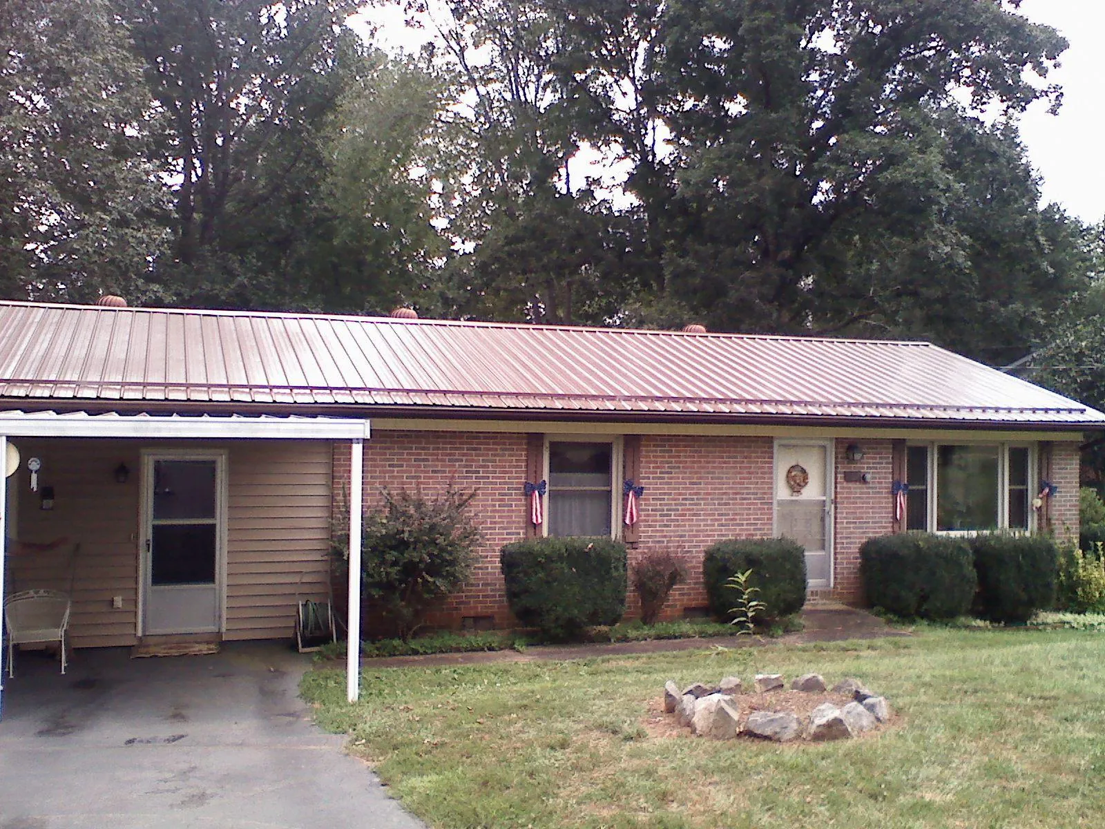 Bronze metal roof and carport on a brick ranch home — Roof Repair work by our crew in Kerby